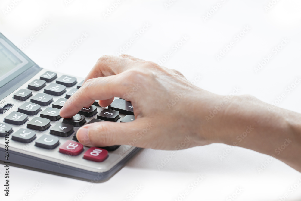 Female hand is touching buttons on the calculator. Female hand is touching buttons on the calculator.
