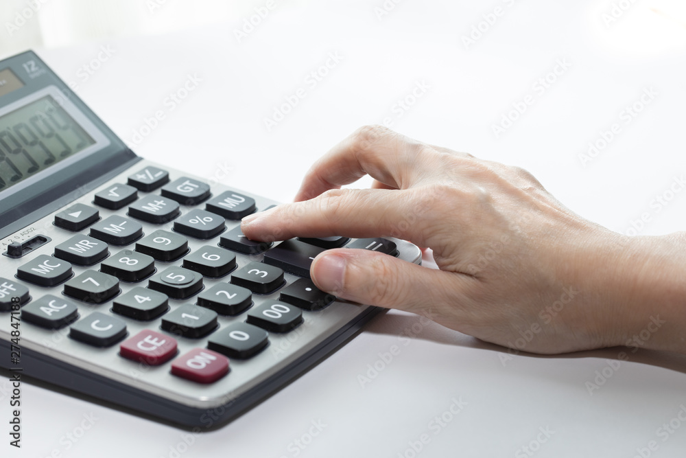 Female hand is touching button on the calculator. Female hand is touching button on the calculator.