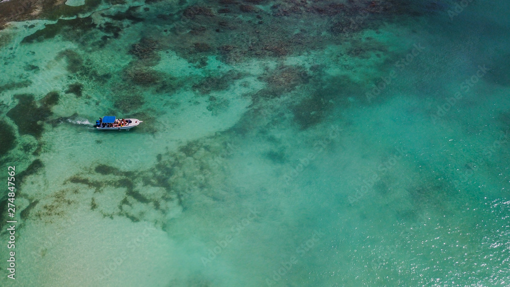 Boat on the sea. Beautiful bay with turquoise water. View from above. Tourist boat on the sea near a coral reef. Yacht in the sea bay. Aerial view. . Boat on the sea. Beautiful bay with turquoise water. View from above. Tourist boat on the sea near a coral reef. Yacht in the sea bay. Aerial view. .