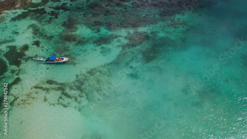Boat on the sea. Beautiful bay with turquoise water. View from above. Tourist boat on the sea near a coral reef. Yacht in the sea bay. Aerial view. .  © Irina