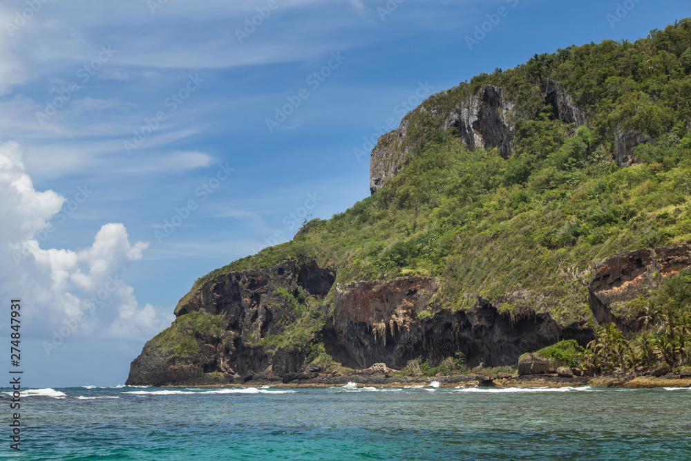 Beautiful Tropical beach in sunny day. Uninhabited island. Landscape of a tropical island and rocky mountains