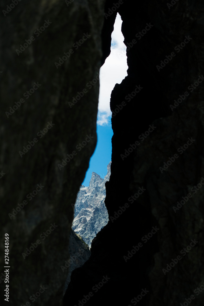 Mountain peak, view from rock hole in Alps.
