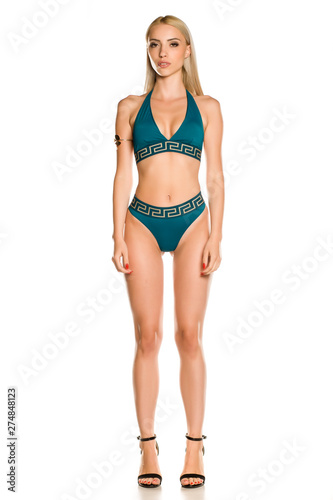 Pretty young lady in blue bikini swimsuit and sandals on white background