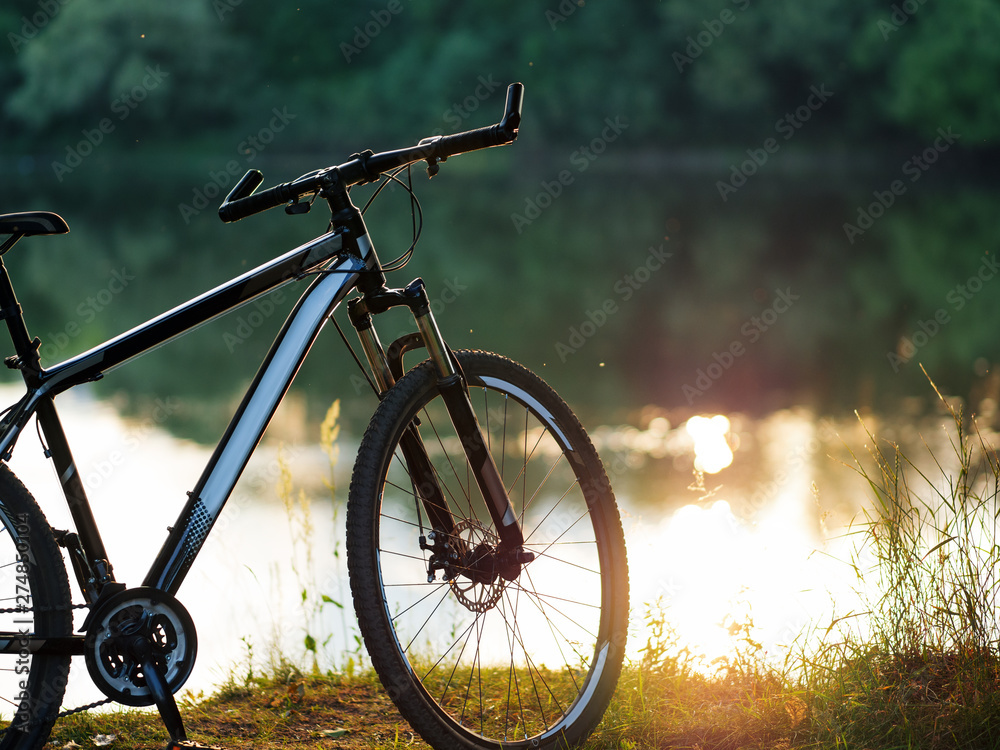 The bike is in the woods by the river. Active lifestyle and Cycling in summer copy space