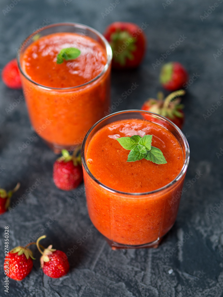 Strawberry red natural homemade smoothie in two glasses on the table Strawberry red natural homemade smoothie in two glasses on the table
