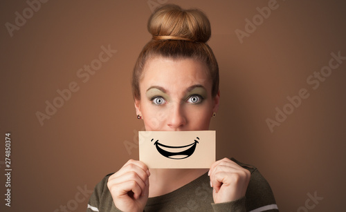 Person holding card in front of his mouth with ironic smile 