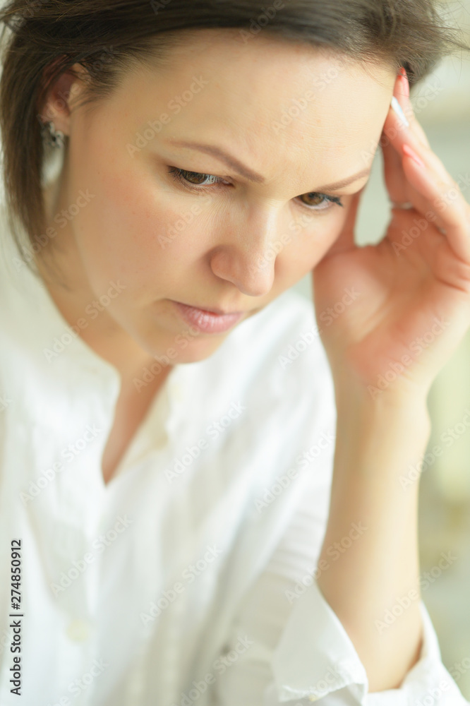 Portrait of young woman with headache posing at home Portrait of young woman with headache posing at home