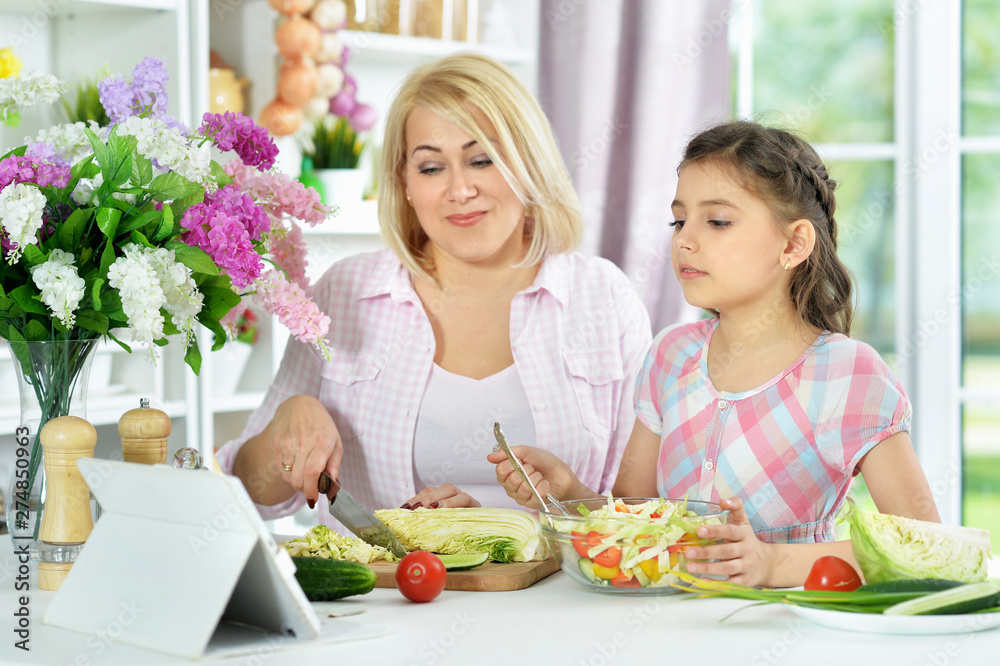 Cute little girl with her mother cooking together