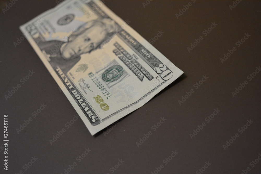 American cash, currency, twenty dollars located on a matte brown background. Financial market, profit from work and business. American cash, currency, twenty dollars located on a matte brown background. Financial market, profit from work and business.
