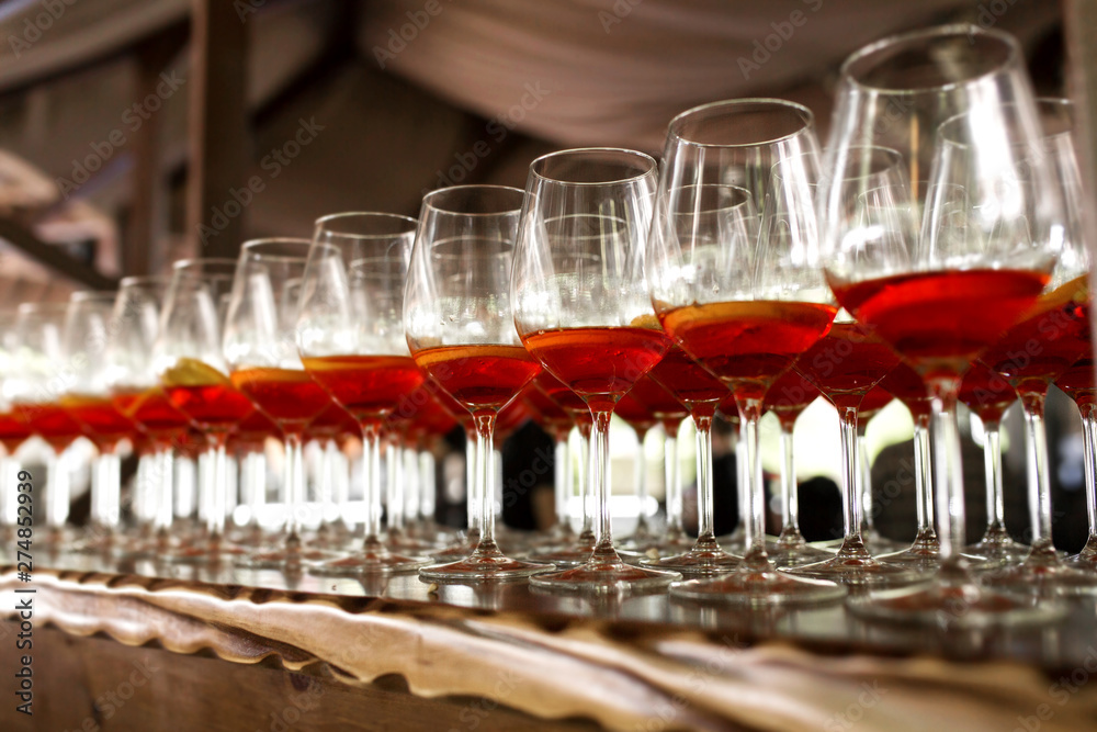 A lot of cocktails at the bar at the wedding party. Glasses with apperol and with a slice of lemon close-up