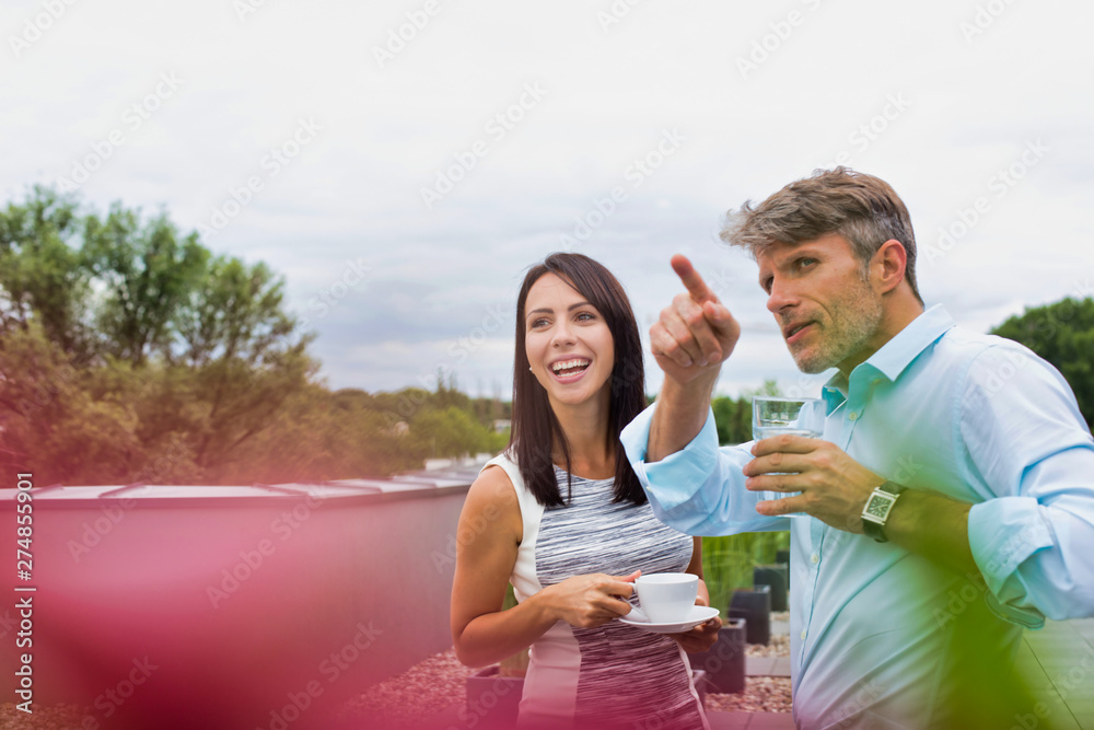 Attractive man and younger woman on a date or at a party outside drinking water and coffee Attractive man and younger woman on a date or at a party outside drinking water and coffee