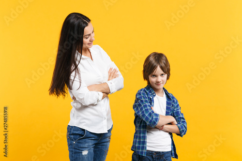 Happy woman in casual clothes have fun with child boy. Mother, little kid son holding hands crossed isolated on yellow orange wall background. Mother's Day, love family, parenthood childhood concept.