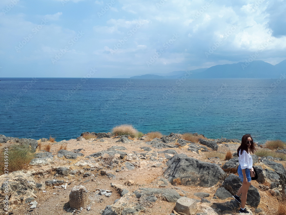 Beautiful woman on sea landscape background in Crete, Greece