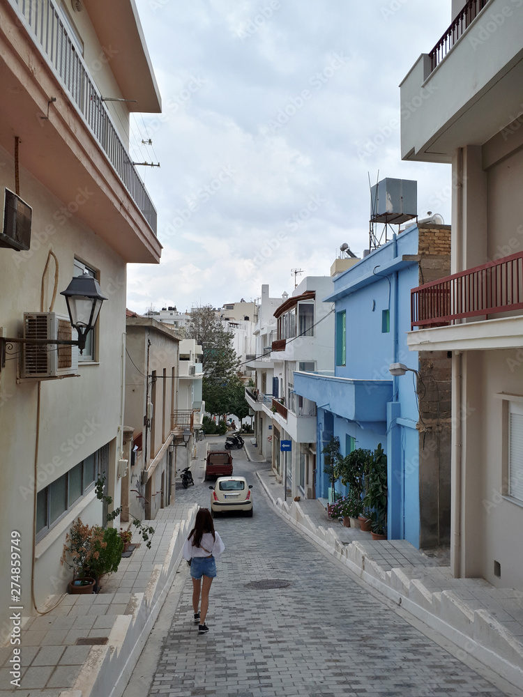 Beautiful woman in cute streets of Agios Nikolaos, Crete, Greece. Traveling to Europe.