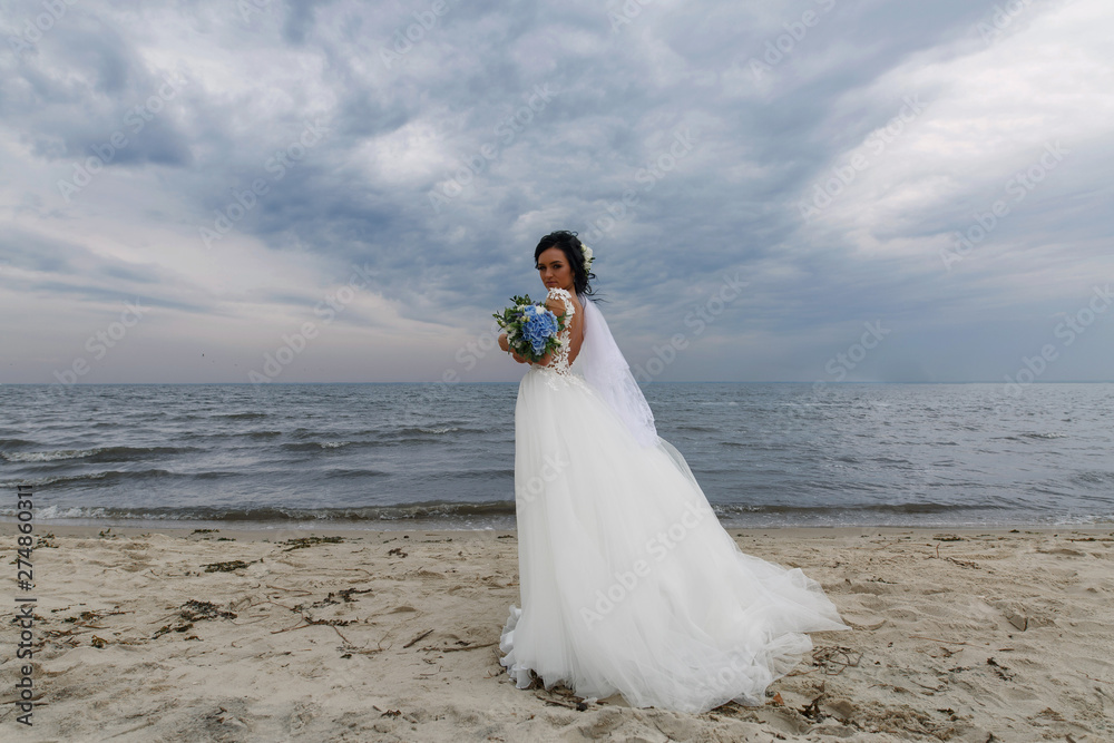 portrait beautiful bride with a delicate wedding bouquet in her hands outdoors.cute young bride in lace dress on the shore. wedding day.wedding concept. portrait beautiful bride with a delicate wedding bouquet in her hands outdoors.cute young bride in lace dress on the shore. wedding day.wedding concept.