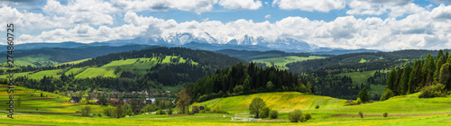Panoramic view over Tatra mountains range and traditional pasture meadows in Pieniny Park, Poland.