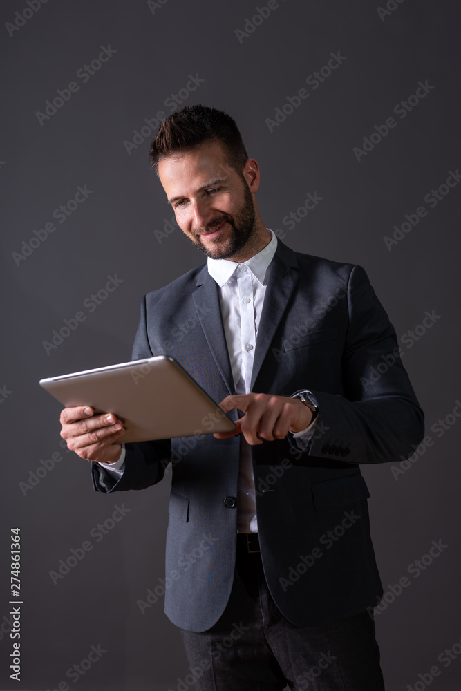 A smiling handsome businessman using a tablet