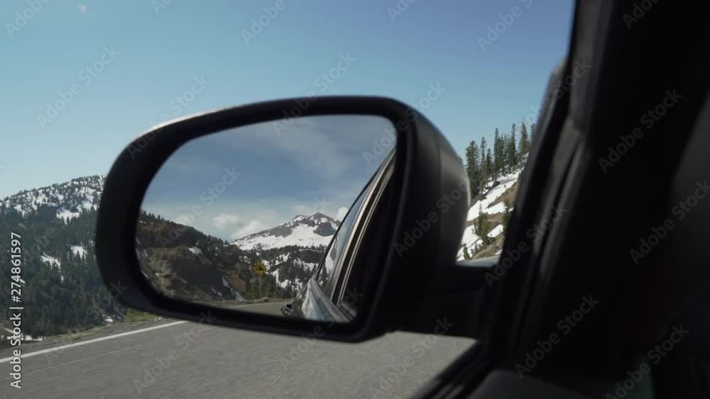 Rock slide danger sign in mirror on car while driving through Lassen Volcanic National Park- Slow Motion. Rock slide danger sign in mirror on car while driving through Lassen Volcanic National Park- Slow Motion.