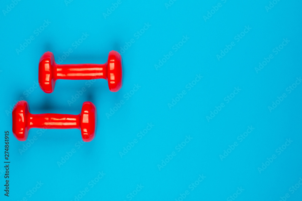 Two dumbbells on blue background Two dumbbells on blue background