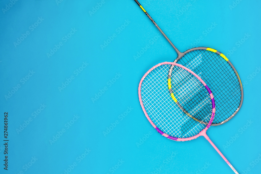 A pair of badminton rackets on blue background. A pair of badminton rackets on blue background.