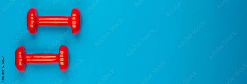 Two dumbbells on blue background Two dumbbells on blue background