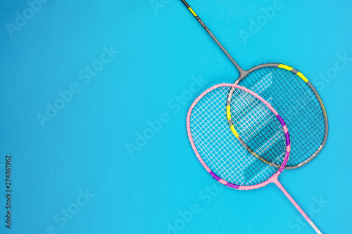 A pair of badminton rackets on blue background.