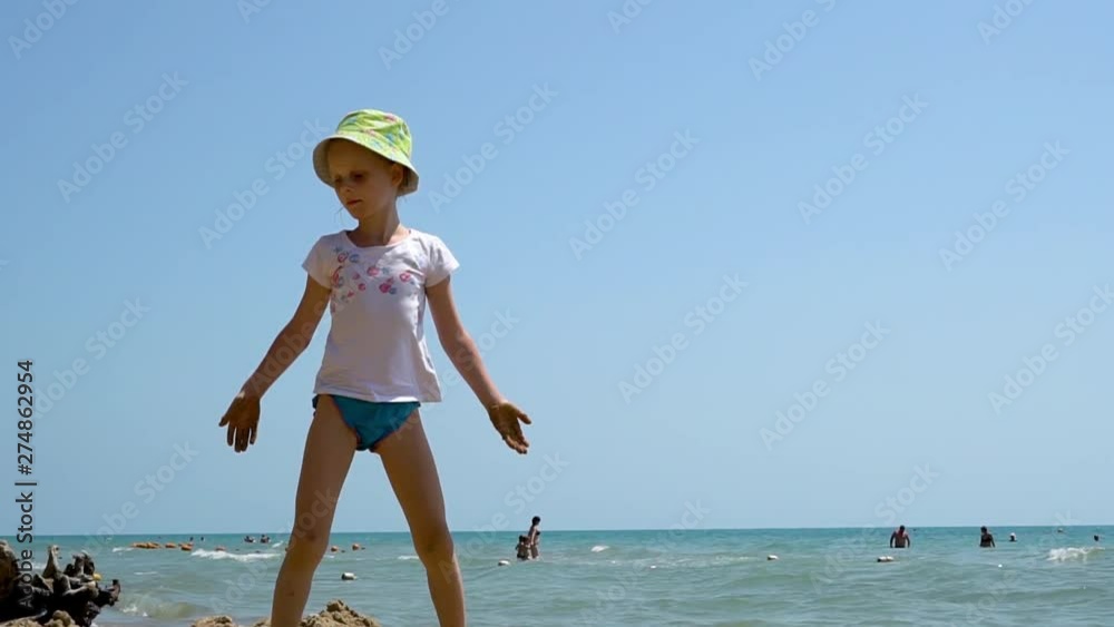 European child playing and walking on a sandy beach by the ocean on a Sunny summer day, vacation, weekend European child playing and walking on a sandy beach by the ocean on a Sunny summer day, vacation, weekend