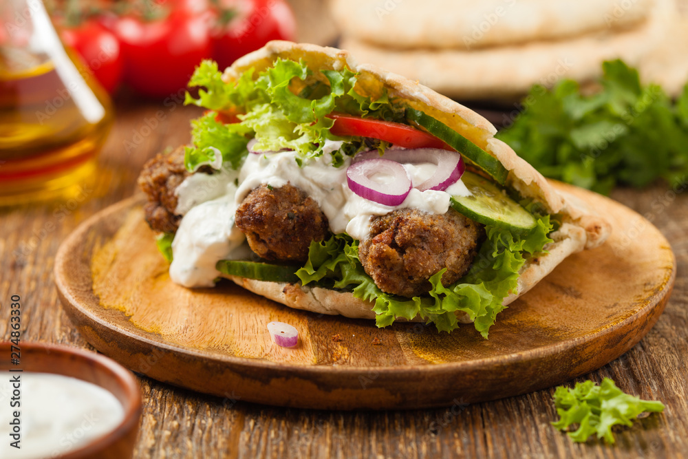 Kebab, kofta in pita, bun. Traditional southern European dish. Front view. Kebab, kofta in pita, bun. Traditional southern European dish. Front view.