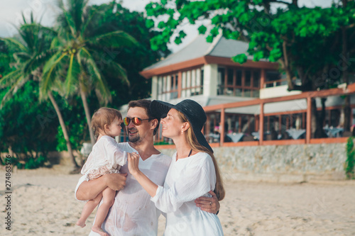 family holiday by the sea: man, woman and child on the beach