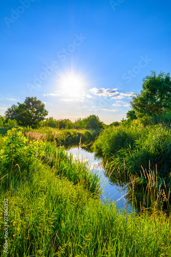 Blue sky over a little creek in the surrounding countryside of Berlin, Germany.