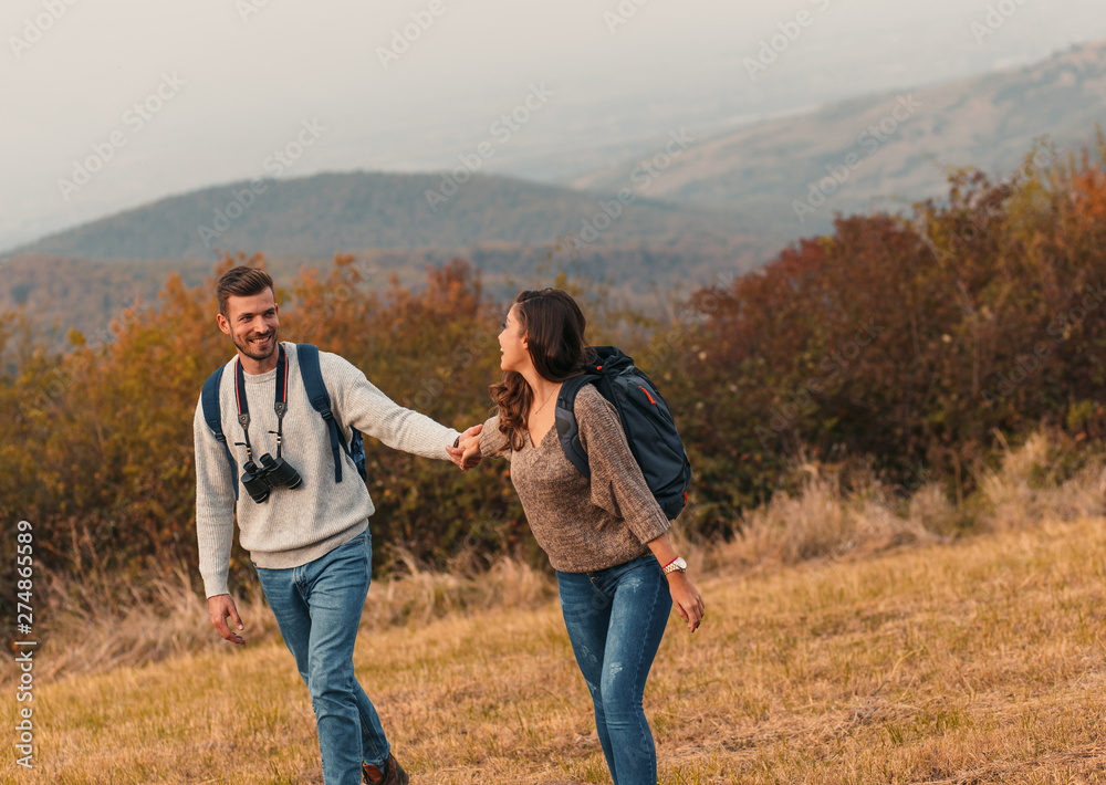 Young couple enjoying hiking together through the countryside.