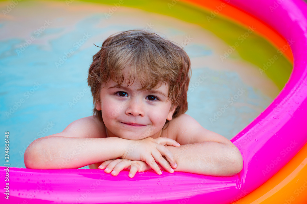 Summer relaxation in the pool. A child lies and relax in a home pool with a smile. Summer rest. Vacations. Cute baby swimming. Resort for the family.