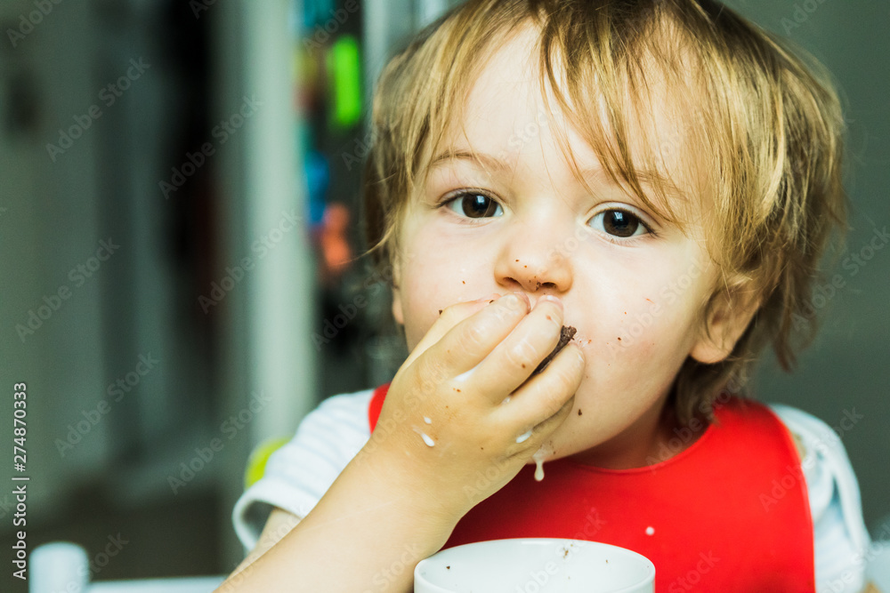 portrait adorable child eating chocolate sponge cake portrait adorable child eating chocolate sponge cake