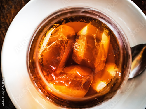 Top view of cold brewed coffee with ice cubes in a clear glass plased on a white plate photo