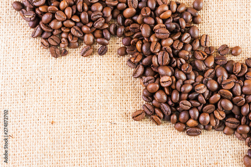 Coffee beans on a background of burlap. Place for text. Concept of making coffee, coffees.