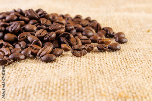 Coffee beans on a background of burlap. Place for text. Concept of making coffee, coffees.