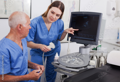 elderly doctor and nurse in cabinet of ultrasound test
