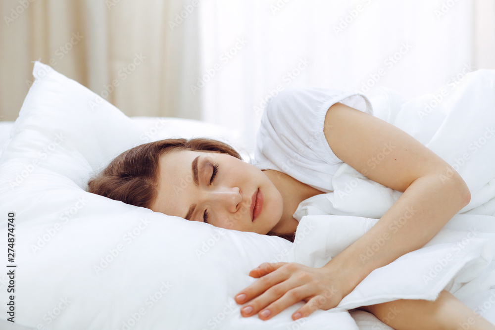 Beautiful young woman sleeping while lying in her bed. Concept of pleasant and rest reinstatement for active life Beautiful young woman sleeping while lying in her bed. Concept of pleasant and rest reinstatement for active life