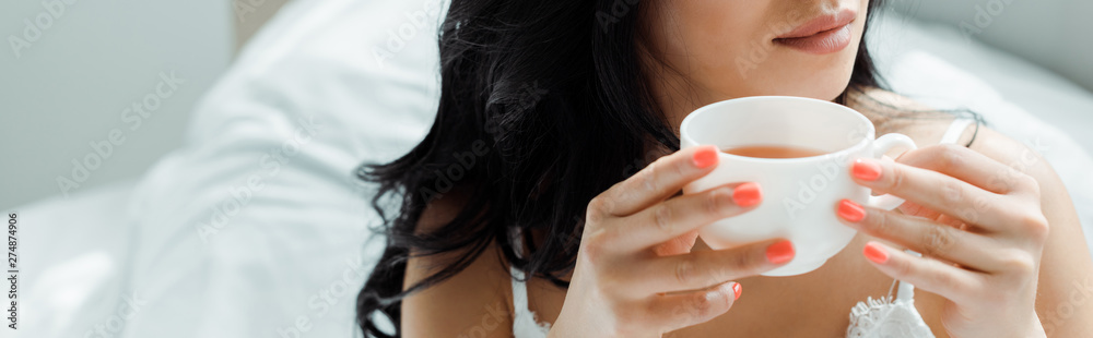 panoramic shot of brunette woman holding cup with drink panoramic shot of brunette woman holding cup with drink