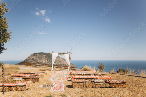 Arch decorated with lively floristics on the background of the sea. Boho style photo