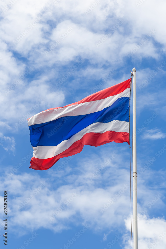 flag of Thailand waving in the wind in front of blue sky