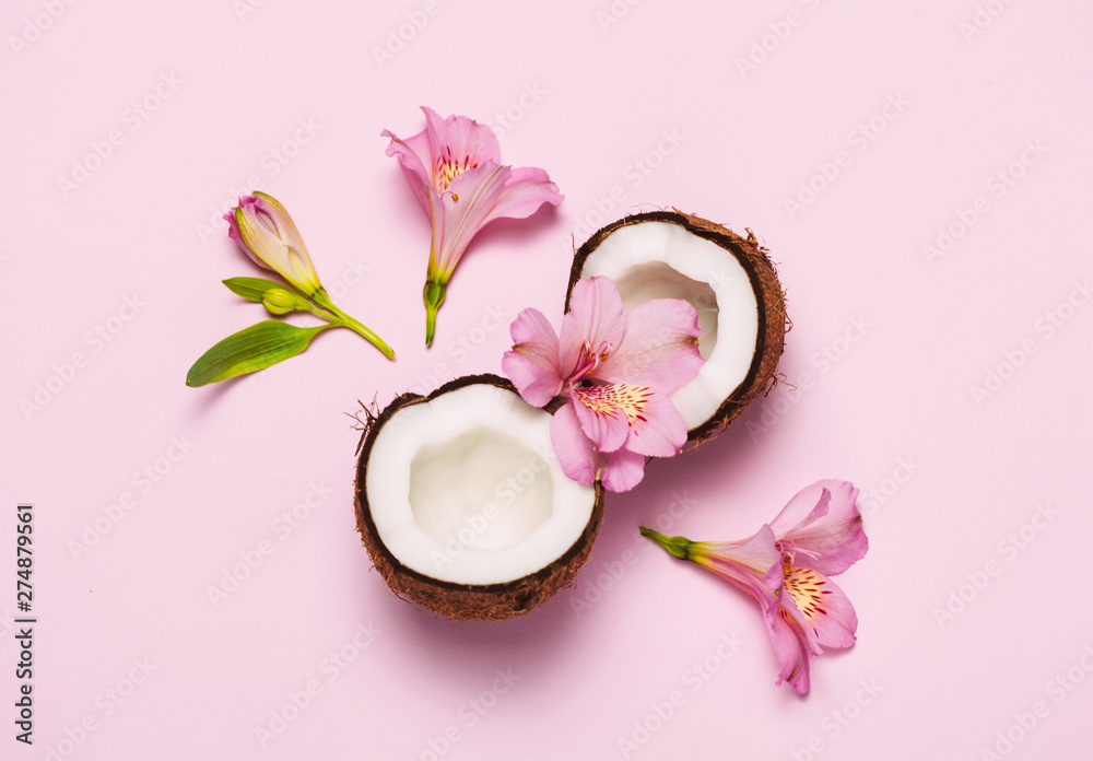 Broken coconut with tropic flowers on pink background. Broken coconut with tropic flowers on pink background.