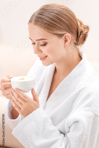 Fototapeta Naklejka Na Ścianę i Meble -  Beautiful young woman drinking coffee in spa salon