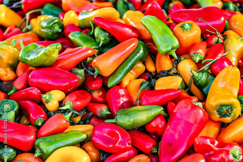 Colorful assortment of fresh peppers displayed in farmers market.