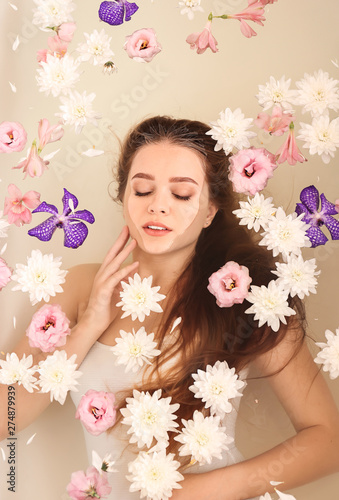 Fototapeta Naklejka Na Ścianę i Meble -  Beautiful young woman taking bath with flowers in spa salon