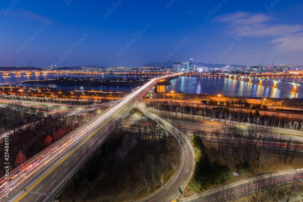 Korea travel, Cars passing in intersection, Han River and bridge at Night in Downtown Seoul, South Korea. Korea travel, Cars passing in intersection, Han River and bridge at Night in Downtown Seoul, South Korea.