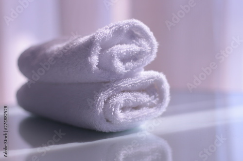 Rolled towels. White rolled towels on table with reflection. Morning relaxation concept.