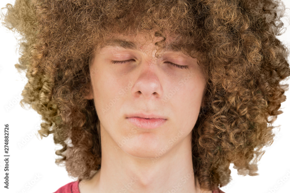 Cropped portrait of a young curly European man with long curly hair and  closed eyes close