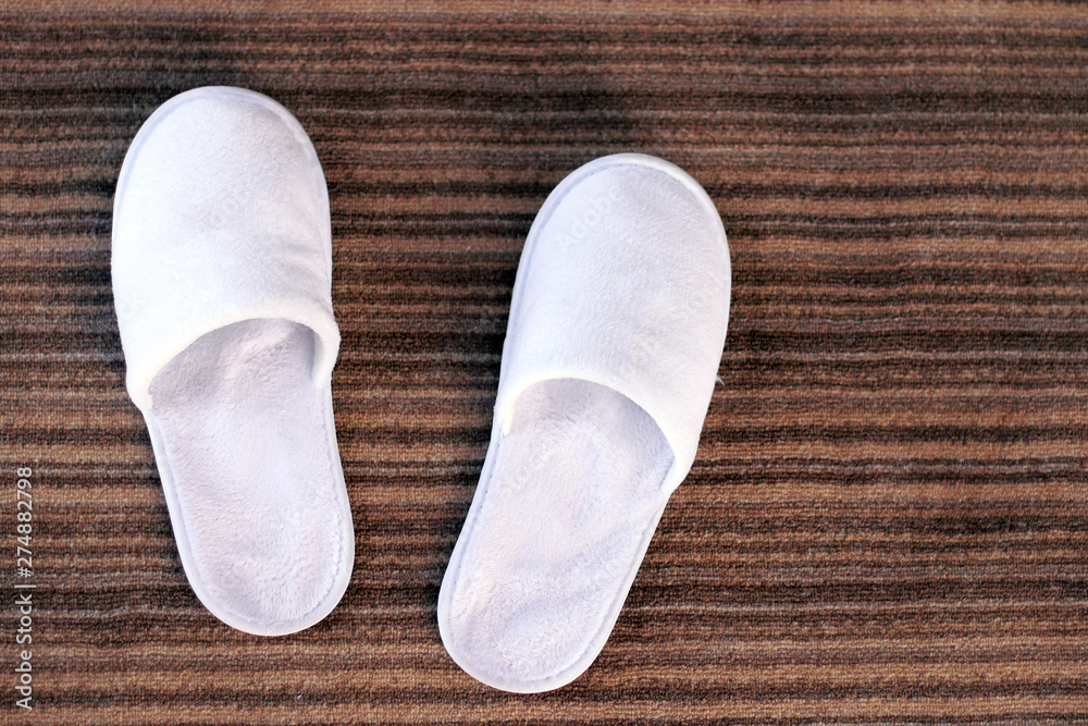 Slippers. White slippers on hotel carpet and sun glares. Slippers. White slippers on hotel carpet and sun glares.