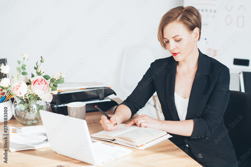 Young beautiful woman working in the office, writting Young beautiful woman working in the office, writting